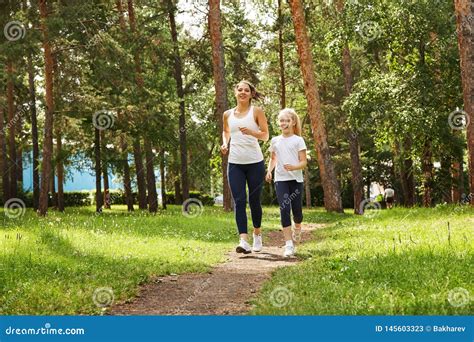 Running Mother And Daughter Woman And Child Jogging In A Park Outdoor