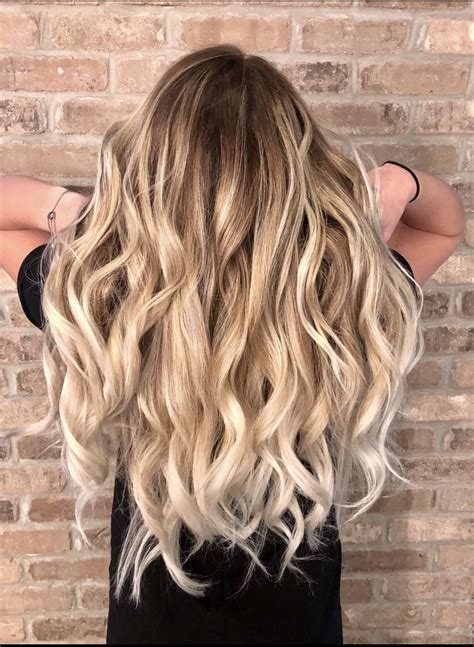 long hair blonde balayage from creamy blonde to icy blonde hair styled with flat iron curls