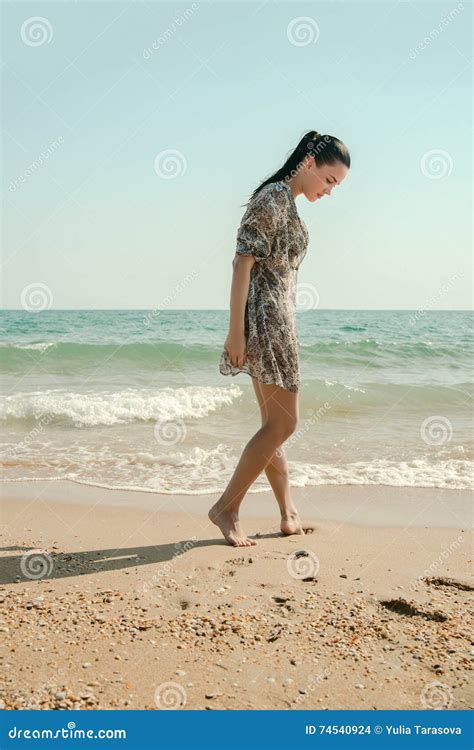 Photograph Of A Beautiful Model Relaxing On A Beach In The Waves Stock