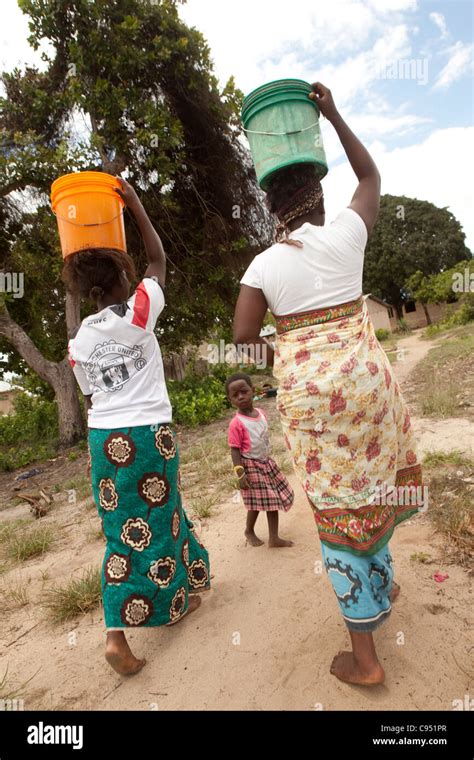Women Carry Water Back From A Rural Well Outside Dar Es Salaam Stock