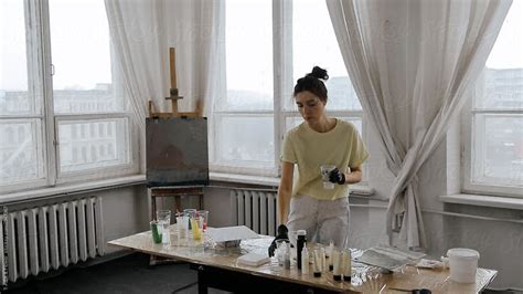 Female Artist Mixing Paint In Cup By Stocksy Contributor Danil Nevsky Stocksy