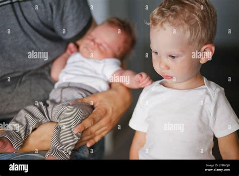 Older Brother With Younger Brother In Fathers Arms Stock Photo Alamy