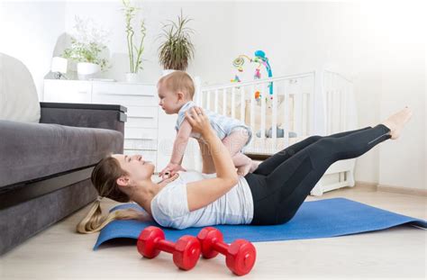 Beautiful Mother With Baby Doing Physical Exercises On Fitness M Stock