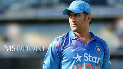 Ms Dhoni Is Wearing Blue Sports Dress And Cap Standing In Blur