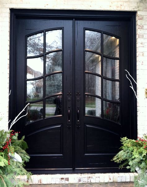 A Black Double Door With Two Sidelights In Front Of A Brick Building