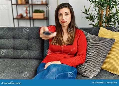 Young Woman Watching Tv Sitting On Sofa At Home Stock Image Image Of Remote Hispanic 250267487