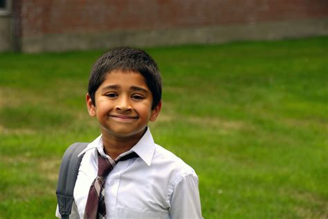 2376099 A Happy Indian School Kid Smiling In Front Of The Classroomr