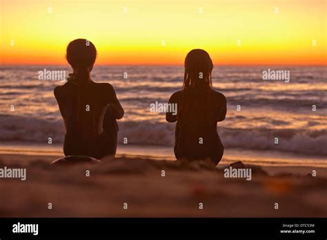 Zwei Mädchen Sitzen Am Strand Bei Sonnenuntergang Blick Auf Das Meer