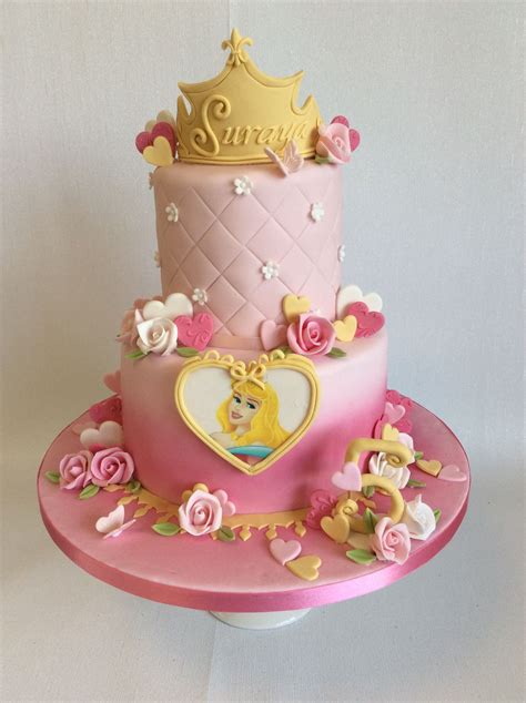 a pink cake decorated with princesses and flowers