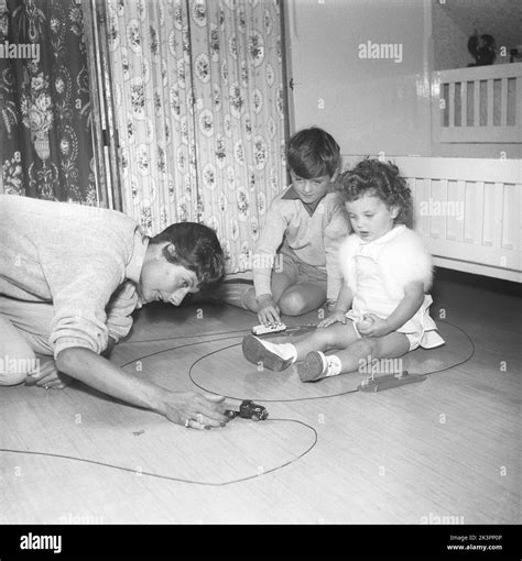 Madre En Los Años 1950s La Sra Erica Sundt Con Sus Dos Hijos Jugando Con Juguetes En El Suelo