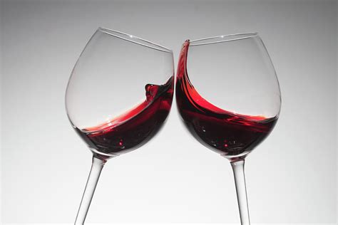 Toasting With Two Glasses Of Red Wine By Dual Dual