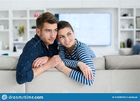 A Young Married Couple Enjoys Sitting In The Large Living Room Stock