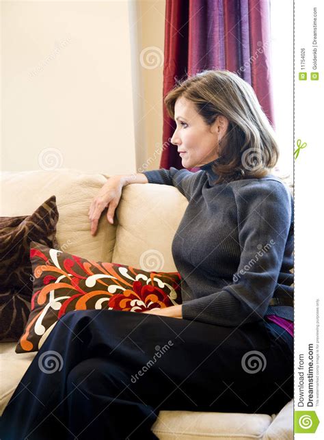 Position a rounded sectional sofa around a circular area rug that s placed in the middle of a square or slightly angular contemporary large living room with sectional couch. Middle-aged Woman Relaxing On Living Room Sofa Stock Photo ...