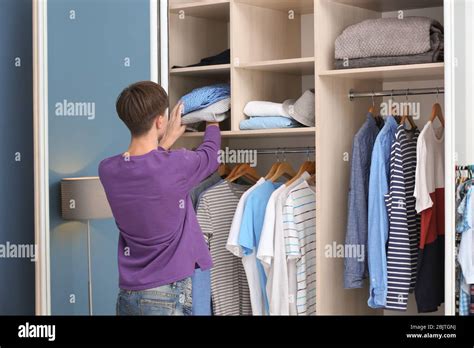 Teenager Putting Clothes Into Wardrobe At Home Stock Photo Alamy