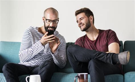 Two Men On Couch Chilling And Playing With Mobile Stock Photo Image