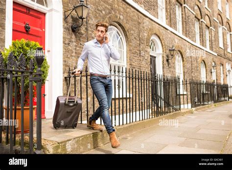 Businessman Leaving House With Wheeled Suitcase London Uk Stock Photo