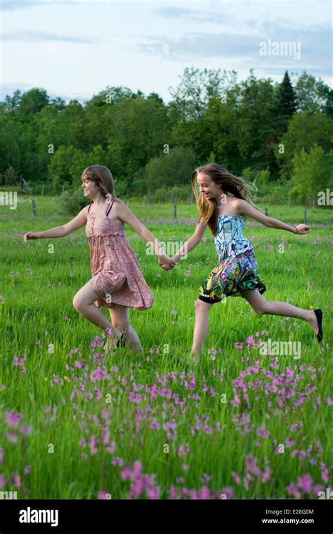 Dos Chicas Adolescentes Corriendo En Un Campo De Flores Al Atardecer