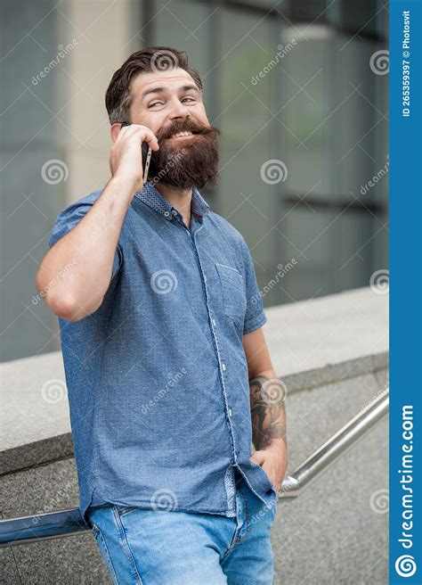 Un Hombre Sonriente Habla En Un Smartphone En La Calle Foto Del Hombre
