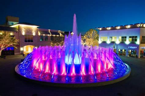 A Brightly Lit Fountain In The Middle Of A Town Square
