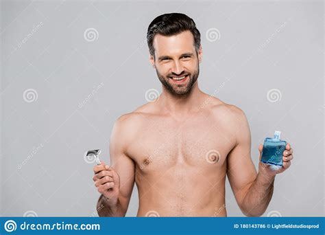 Cheerful And Muscular Man Holding After Shave Lotion And Razor Stock Photo Image Of Razor