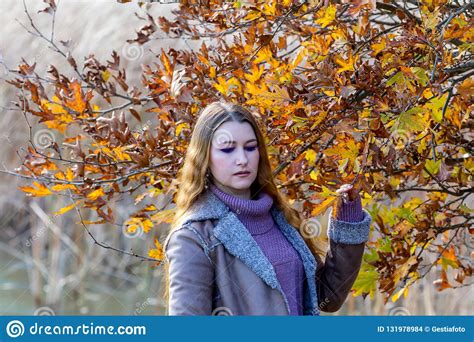 Young Beautiful Woman On The Background Of The Autumn