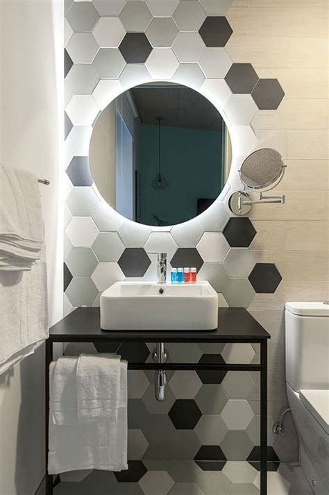 Un Baño Pequeño Con Azulejo Hexagonal Y Un Espejo Redondo