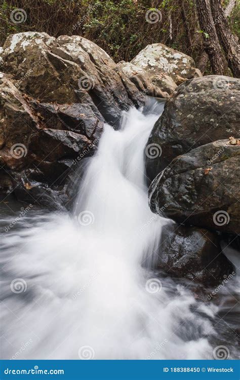 Vertical Shot Of A Beautiful Waterfall Flowing Through Rock Formations