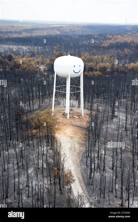 Water Tower With Smiley Face Painted On It Stand Above Wildfire Damage