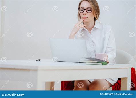 Thoughtful Stunning Blonde In Glasses Working On Laptop At Home Stock