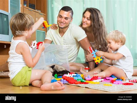 Felices Padres Con Dos Pequeños Niños Jugando Con Juguetes De Plástico