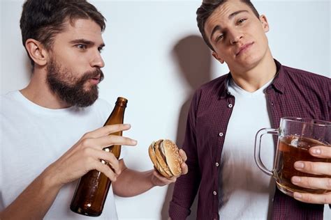Premium Photo Two Men Have Fun Drink Beer And Eat Fast Food