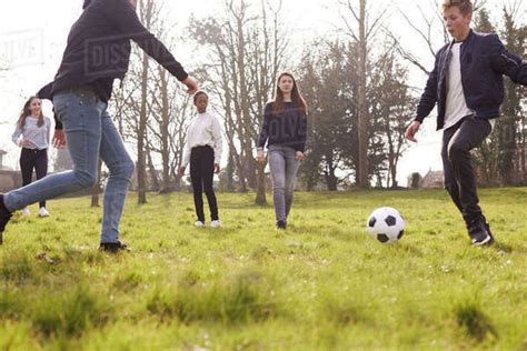 Group Of Teenagers Playing Soccer In Park Together Stock Photo Dissolve