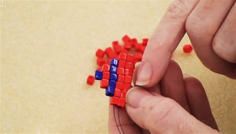 A Person Is Playing With Red And Blue Cubes