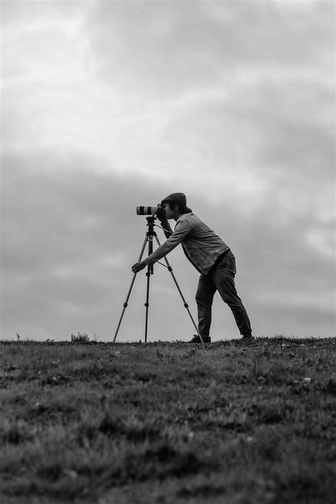 Grayscale Photo Of Man Standing Beside Camera Photo Free Grey Image