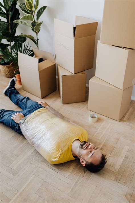Exhausted Man Tied Up With Tape Lying Near Carton Boxes · Free Stock Photo