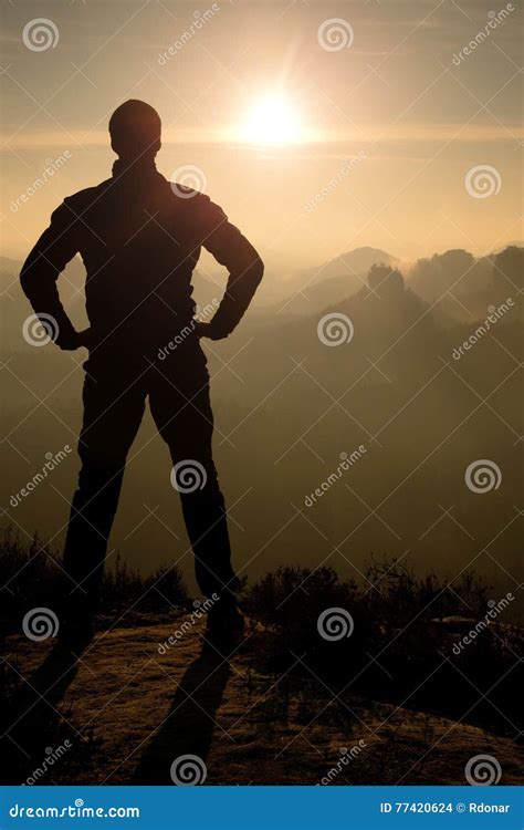 Self Confident Man On Rock Watching Foggy Landscape Up To Horizon Stock
