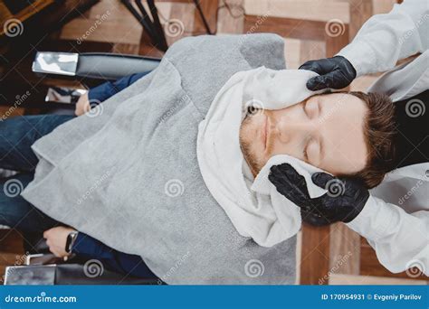 barber steam face skin of man with hot towel before royal shave in barbershop stock image