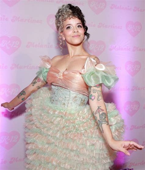 A Woman In A Dress With Tattoos On Her Arms