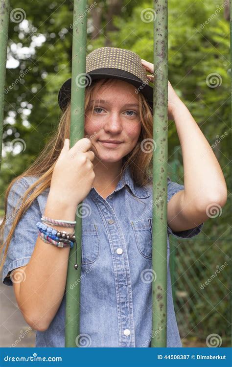 Fashionable Pretty Girl In The Park Behind The Fence Travel Stock