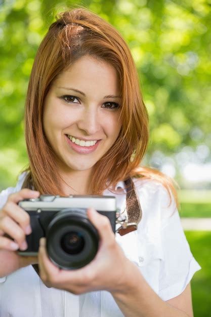 Premium Photo Pretty Redhead Taking A Photo In The Park