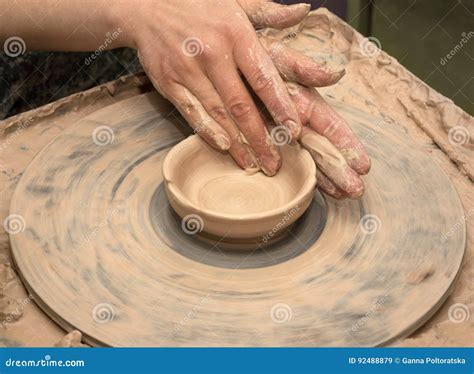 Woman Hands In Clay At Process Of Making Clay Bowl On Pottery Wheel