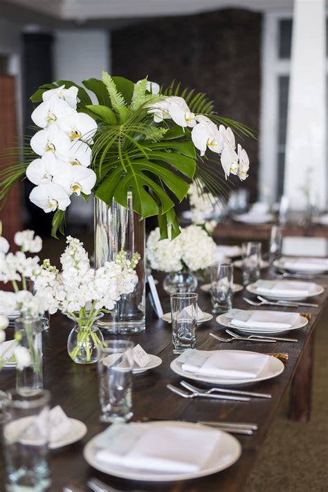 Wedding Centerpieces White Phaelaenopsis Orchids Monstera Leaves Palms Tropical Wedding