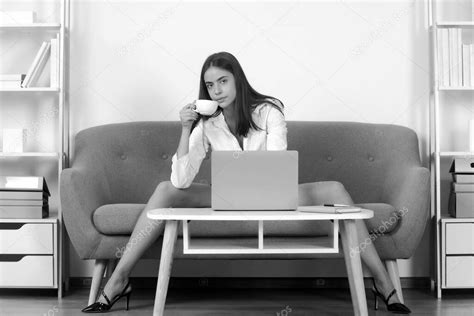 seductora secretaria sexy freelancer con piernas sexy sentarse en el sofá en la oficina mujer