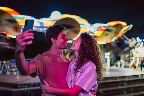 Photo Libre De Droit De Un Jeune Couple Prend Des Selfies Dans Un Parc Dattractions Banque D