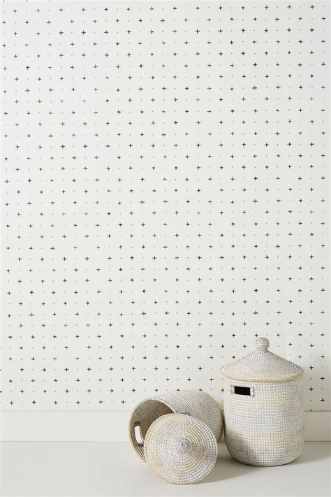 Two White Baskets Sitting On Top Of A Table Next To A Wall Covered In Dots