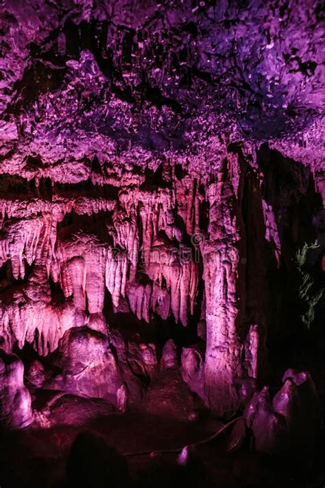 Stunning Cave With Stalactites And Stalagmites With Violet Illumination