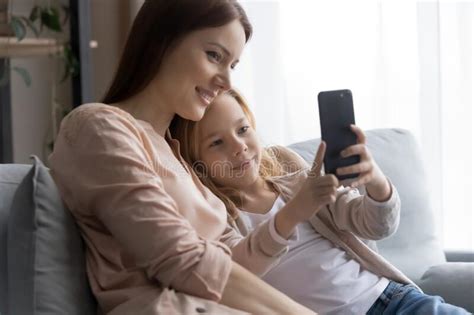 Happy Caucasian Mom And Teen Daughter Talk On Cellphone Stock Image