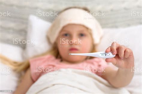 Sick Little Child Girl Lying In Bed With Thermometer Stock Photo