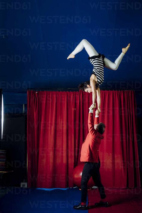 Male And Female Acrobats Performing Together In Circus Stock Photo