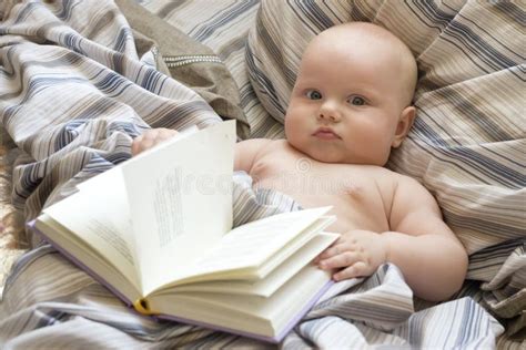 Weinig Baby Ligt In Bed Met Een Boek Stock Afbeelding Image Of